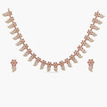 A picture of an Indian artificial jewelry set: a gold-plated necklace and earrings featuring teardrop-shaped red gemstones with Cubic Zirconia on a white background. 